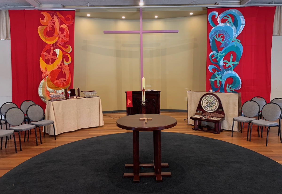 The inside of the South Yarra Community Baptist Church set up for worship with bright red Pentecost banners