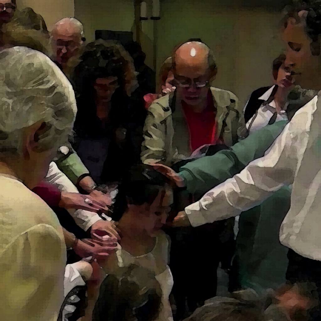 A church congregation prayerfully laying hands on a young woman as she kneels in prayer